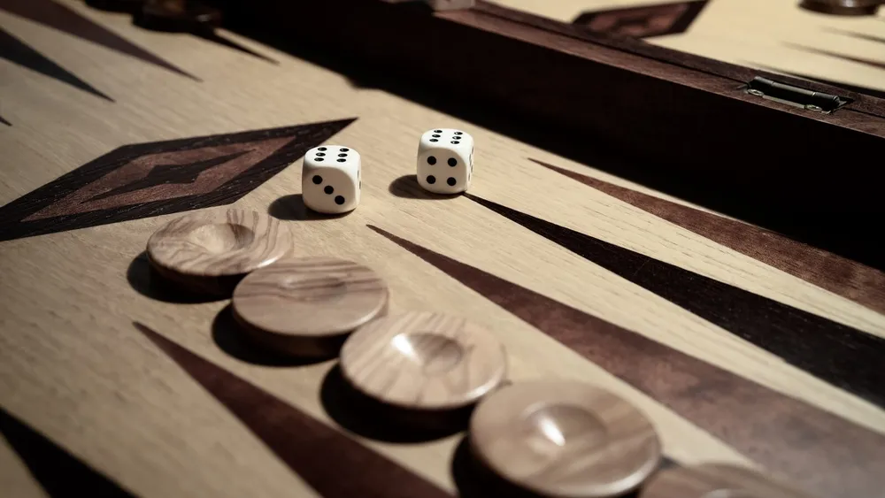 Backgammon-Würfel auf einem Spielbrett aus Olivenholz