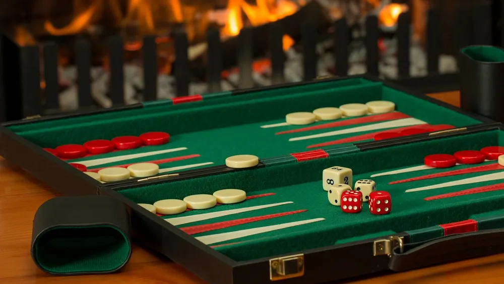 Backgammon-Koffer mit Spielsteinen vor einem Kaminfeuer